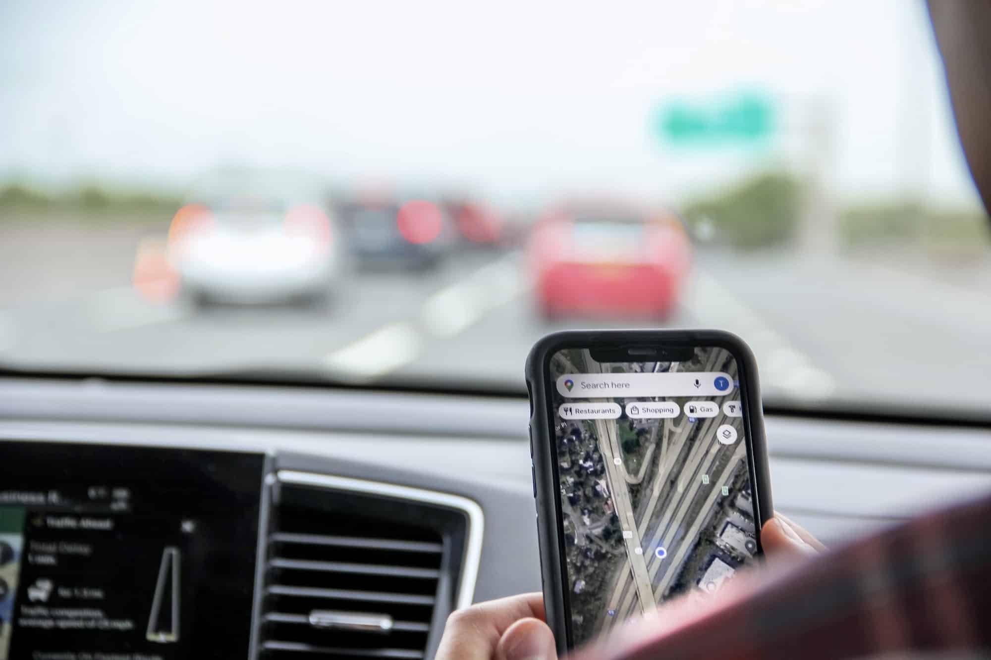 Gen Z using Google map app during road trip in conjunction with vehicle GPS for accurate directions